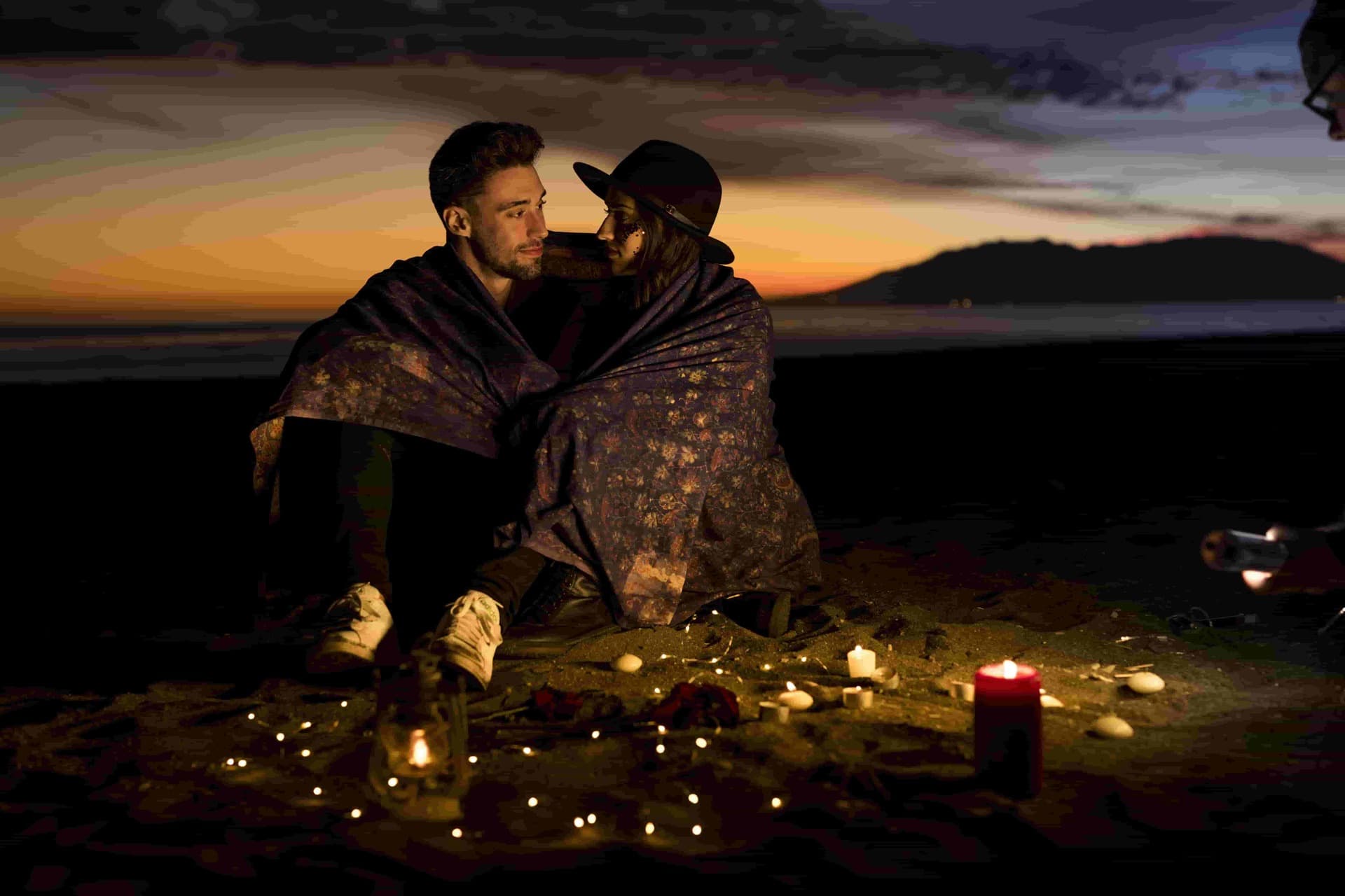 Jeune couple assis sur le bord de mer
